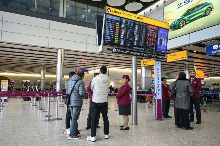 Le personnel de Qatar Airways renseigne des voyageurs à l’aéroport de Londres-Heathrow, le 1er mars 2026, alors que les vols sont gravement perturbés en raison de la guerre au Moyen-Orient