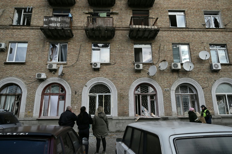 Des habitants regardent un immeuble résidentiel endommagé par des frappes aériennes russe à Kiev, le 22 octobre 2025 en Ukraine