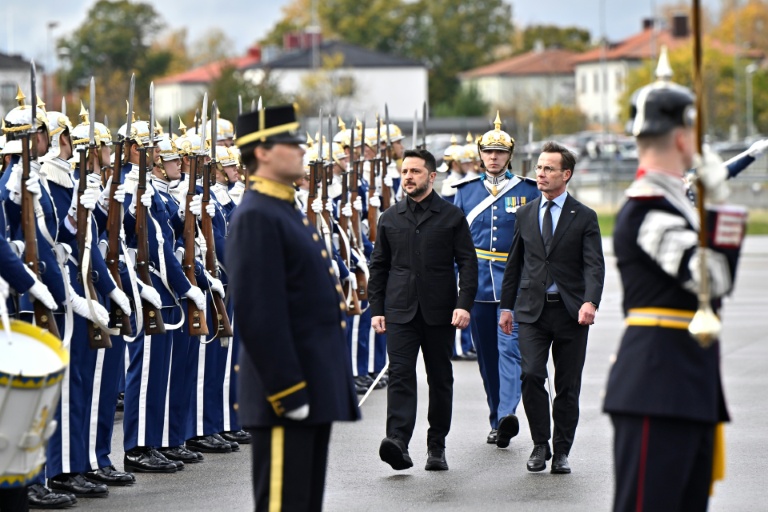 Le Premier ministre suédois Ulf Kristersson (c,d) et le président ukrainien Volodymyr Zelensky passent en revue la garde d'honneur à l'aéroport de Linköping, le 22 octobre 2025 en Suède