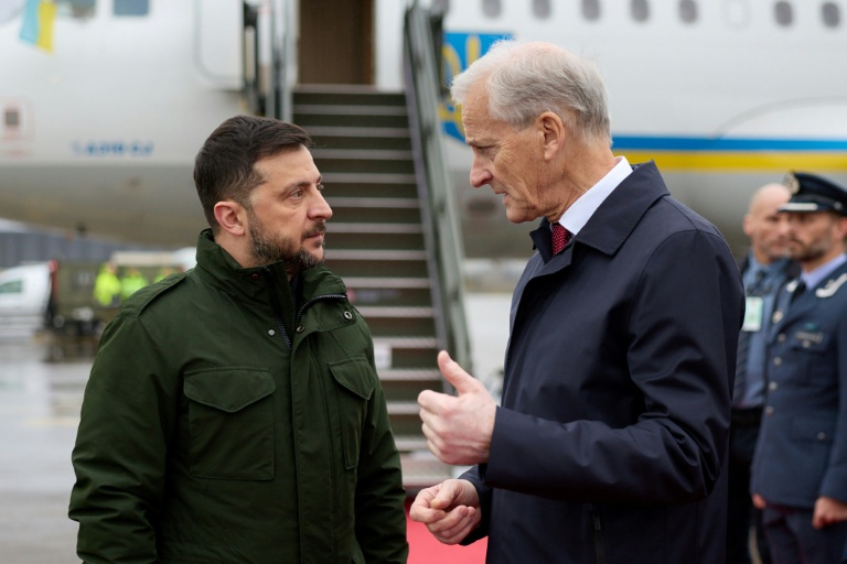 Photo publiée par le service de presse de la présidence ukrainienne, le 22 octobre 2025, du Premier ministre norvégien Jonas Gahr Støre (d) accueillant le président ukrainien Volodymyr Zelensky (g) à son arrivée à l'aéroport d'Oslo