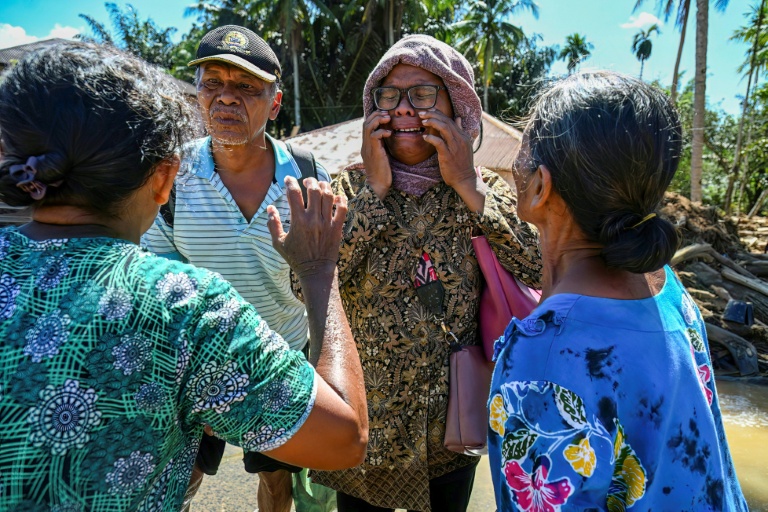 Une femme retrouve ses proches après que leur village a été frappé par une crue éclair à Tukka, dans le district de Tapanuli central, province de Sumatra du Nord, le 3 décembre 2025