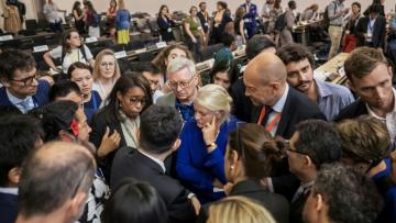 Des délégués de plusieurs gouvernements se concertent dans la grande salle des Nations Unies après l'annonce d'une extension dans la durée des négociations dans l'espoir de parvenir à un accord sur un texte de traité contre la pollution plastique, jeudi 14 aout 2025 à Genève 
