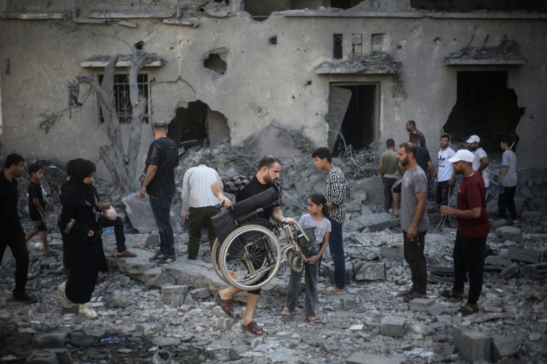 Des Palestiniens inspectent un immeuble détruit par une frappe israélienne à Deir al-Balah, dans le centre de la bande de Gaza, le 29 juillet 2026
