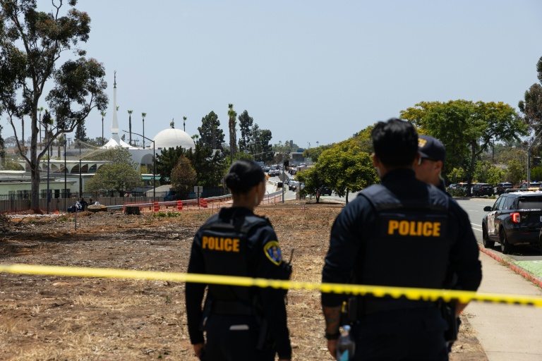 Deux membres des forces de l'ordre près de la mosquée de San Diego, en Californie, où trois personnes ont été tuées et où les deux tireurs présumés ont été retrouvés morts, le 18 mai 2026