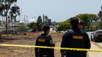 Deux membres des forces de l'ordre près de la mosquée de San Diego, en Californie, où trois personnes ont été tuées et où les deux tireurs présumés ont été retrouvés morts, le 18 mai 2026