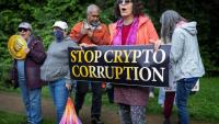 Des manifestants devant le Trump National Golf Course à Sterling, en Virginie, le 22 mai 2025, où le président Donald Trump participe à un dîner privé dans son club pour les 220 plus gros détenteurs de sa cryptomonnaie