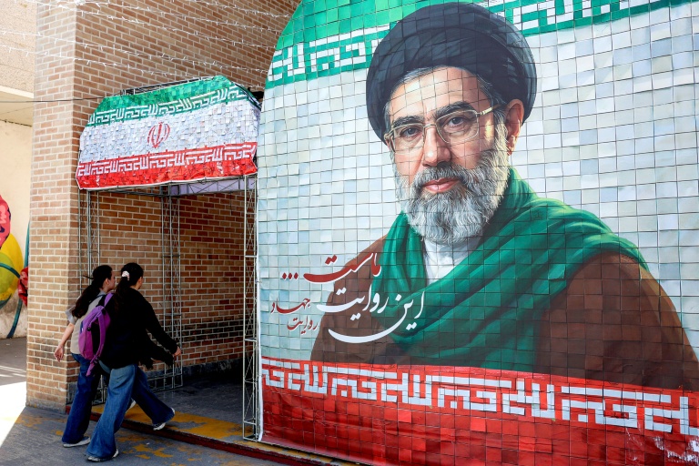 Des femmes passent devant un portrait de l'actuel guide suprême iranien, l'ayatollah Mojtaba Khamenei, dans une rue à Téhéran, le 6 mai 2026