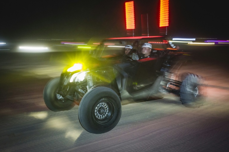 Deux hommes participent à une course nocturne dans leur buggy, près de Somerton, en Arizona, le 18 octobre 2026