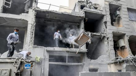 Des Iraniens dégagent les décombres de maisons détruites par des frappes israélo-américaines, le 15 mars 2026 à Téhéran