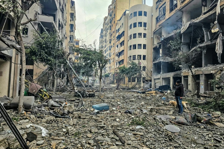 Un homme et son chien au milieu des décombres après une frappe aérienne israélienne dans le quartier de Haret Hreik, dans la banlieue sud de Beyrouth, le 15 mars 2026
