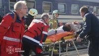 Photo diffusée par le Service ukrainien des situations d'urgence le 29 octobre 2026 montrant des secouristes ukrainiens transportant sur une civière une personne blessée après une attaque aérienne contre la gare de Dnipro, en Ukraine
