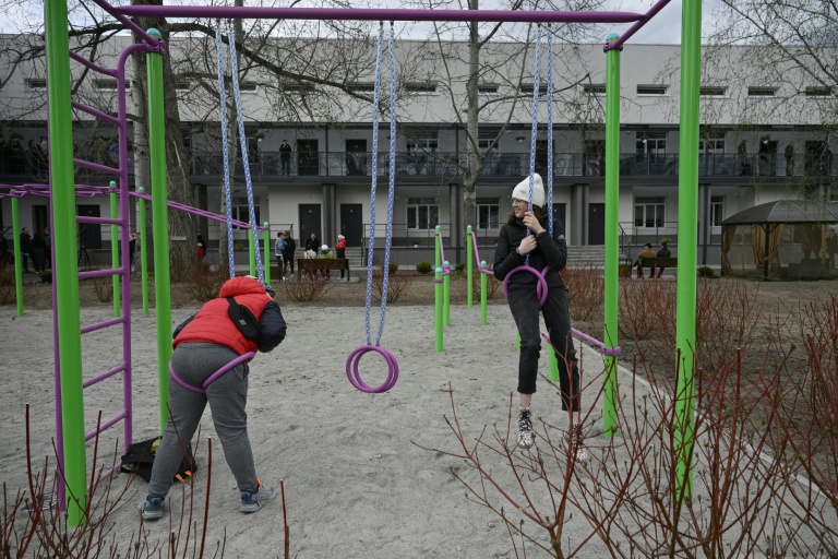 Des enfants jouent devant un bâtiment rénové pour accueillir des déplacés de guerre, le 25 avril 2026 à Slavoutytch dans le nord de l'Ukraine