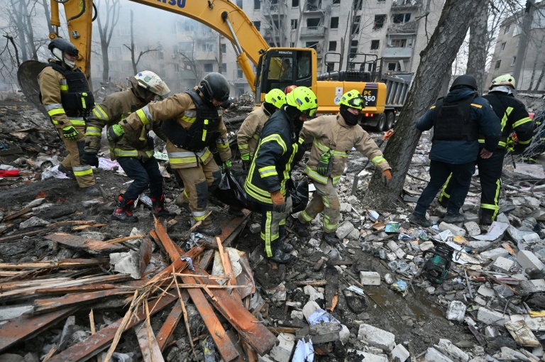 Des sauveteurs évacuent un corps extrait des décombres d'un immeuble touché par un bombardement à Kharkiv, dans l'est de l'Ukraine, le 7 mars 2026