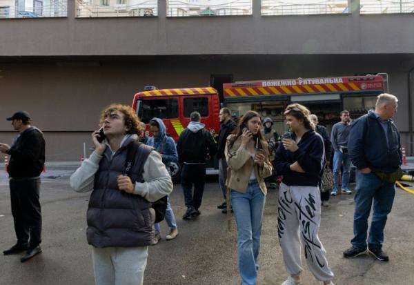 Des habitants observent un immeuble résidentiel endommagé après une frappe de drone russe à Kiev, le 25 septembre 2026