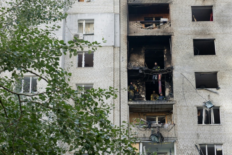 Des pompiers dans un immeuble endommagé par une frappe de drone russe à Kiev, le 25 septembre 2026