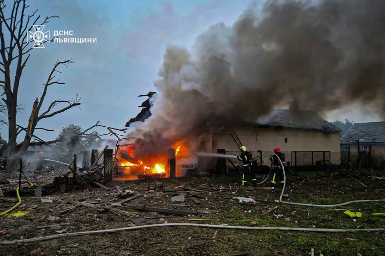 Photo prise et diffusée par les services d'urgence ukrainiens, le 5 octobre 2025, montrant une voiture en feu dans la cour d'un immeuble résidentiel après une attaque aérienne russe à Zaporijjia, en Ukraine