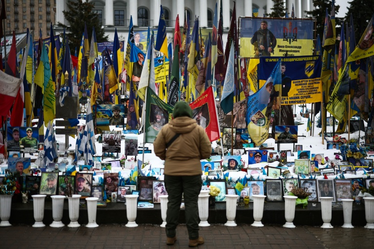 Une personne se tient devant un mémorial de fortune dédié aux soldats ukrainiens et étrangers tombés au combat, sur la place de l’Indépendance à Kiev, le 23 février 2026