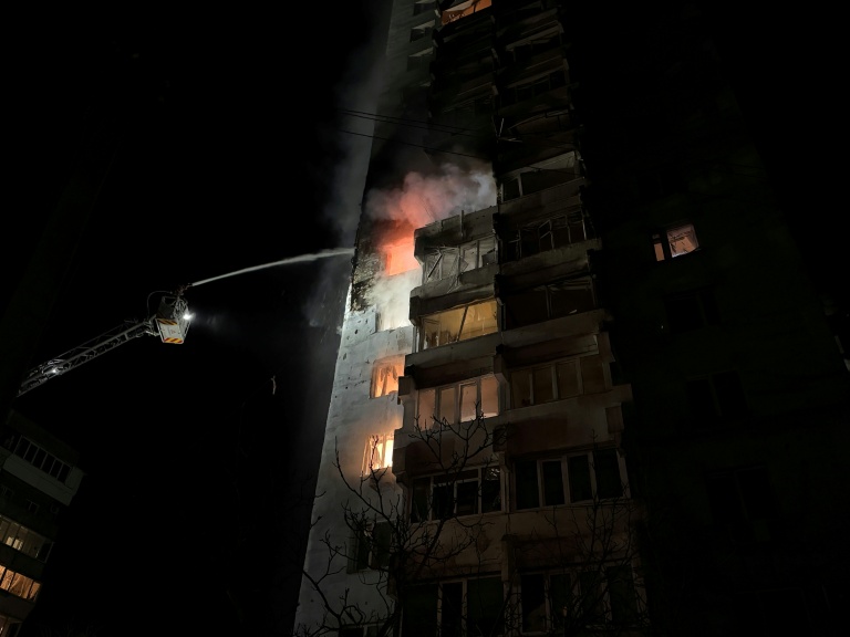 Des pompiers ukrainiens éteignent un incendie dans un immeuble résidentiel causé par une frappe russe sur Zaporijjia dans le sud de l'Ukraine le 24 mars 2026