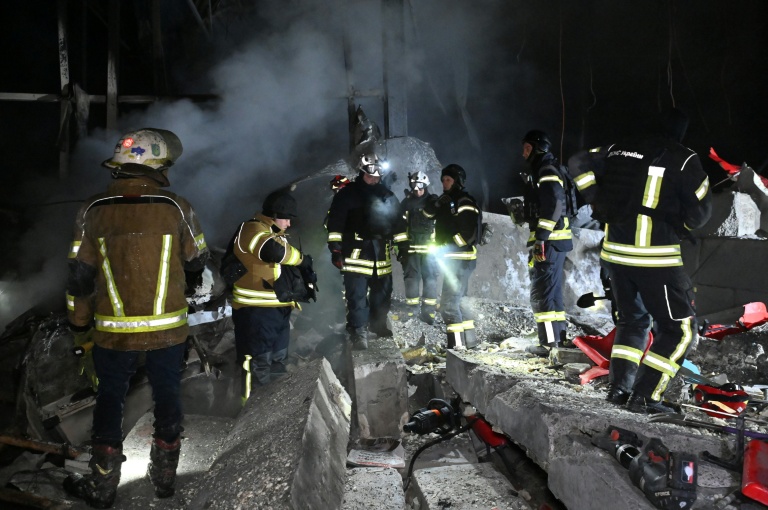 Des pompiers sur le site d'un entrepôt de la compagnie postale Nova Poshta endommagé par un bombardement russe dans un village près de Kharkiv, le 13 janvier 2026 en Ukraine