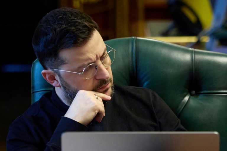 Le président ukrainien Volodymyr Zelensky écoute ses interlocuteurs - le président français, le Premier ministre anglais et le chancelier allemand - lors d'un échange téléphonique, dans son bureau à Kiev, le 21 novembre 2025 