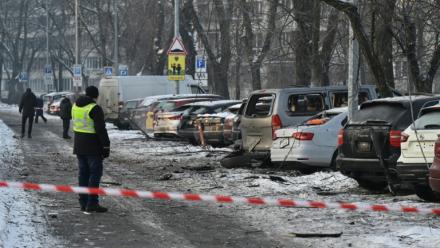 Des habitants devant des voitures endommagées sur un site où des débris de drones russes sont tombés durant une attaque arérienne massive russe, à Kiev en Ukraine le 20 janvier 2026