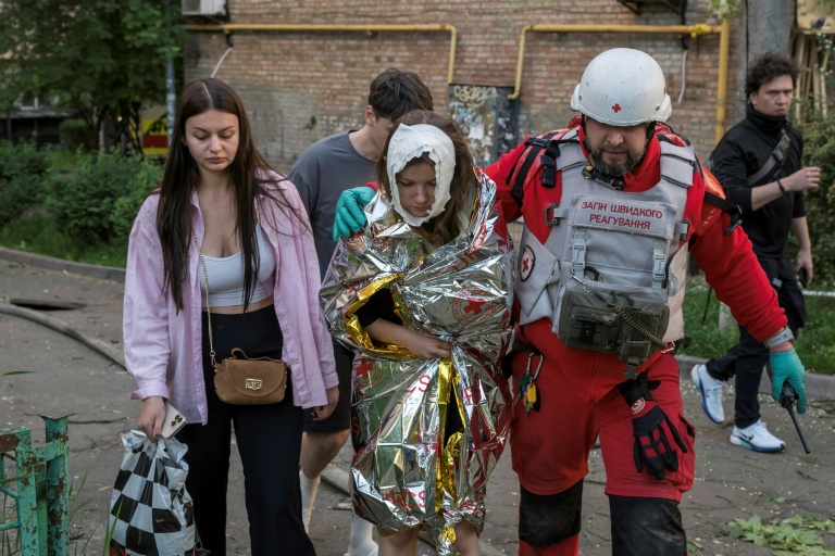 Un secouriste évacue une personne blessée dans les intenses bombardements russes nocturnes qui ont particulièrement visé la capitale ukrainienne, le 24 mai 2026 à Kiev 