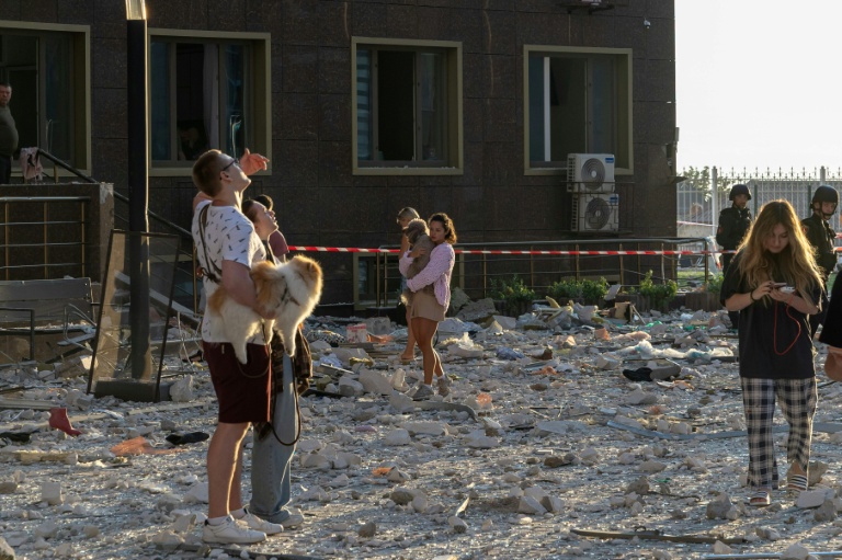 Des habitants se tiennent à l'extérieur d'un immeuble d'habitation endommagé par des frappes de missiles et de drones russes sur la ville portuaire ukrainienne d'Odessa, le 12 septembre 2026  