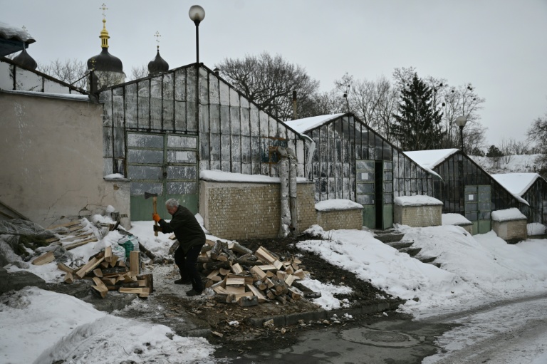 Le bénévole Volodymyr Vynogradov coupe du bois destiné à chauffer les serres du jardin botanique national Gryshko de l'Académie nationale des sciences d'Ukraine à Kievv, le 11 février 2026