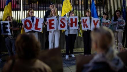 Des membres de la diaspora ukrainienne tiennent des pancartes formant le nom Oleshky (Olechky) devant l'ambassade américaine à Varsovie, le 6 octobre 2026, en Pologne