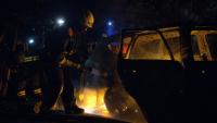 Des pompiers éteignent une voiture en feu détruite lors d'attaques nocturnes de drones à Kiev, le 30 mai 2023