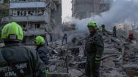 Les secouristes dans les ruines d'un immeuble détruit par une frappe russe à Kiev, le 14 mai 2026