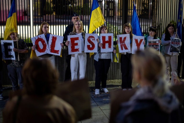 Des membres de la diaspora ukrainienne tiennent des pancartes formant le nom 