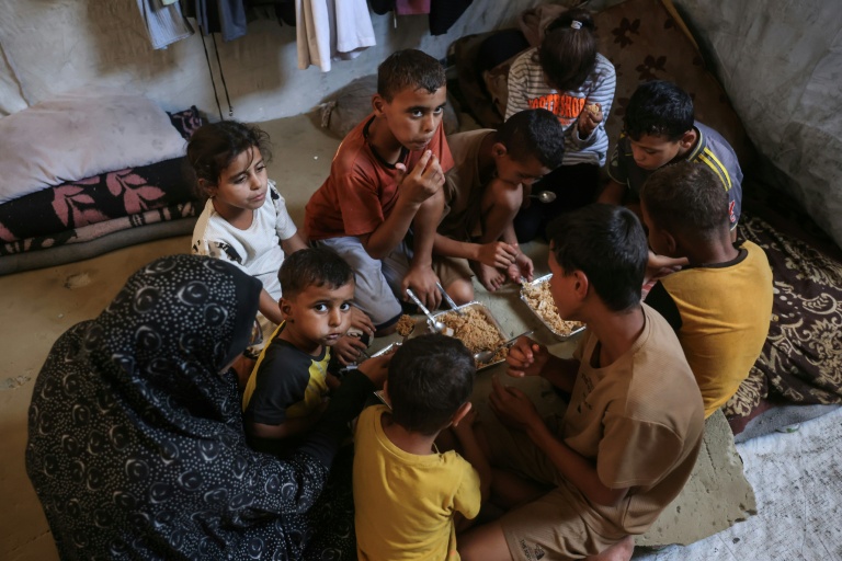 Nihaya Al-Masri(G), une Palestinienne déplacée qui vit avec ses huit enfants sous une tente à Khan Younès, dans le sud du territoire palestinien, le 6 octobre 2026 
