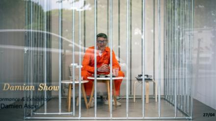 L'artiste Damien Aspe visible à travers la vitrine de sa galerie, où il s'est enfermé dans une cage pour dénoncer l'emprise des GAFAM, le 28 avril 2028 à Toulouse