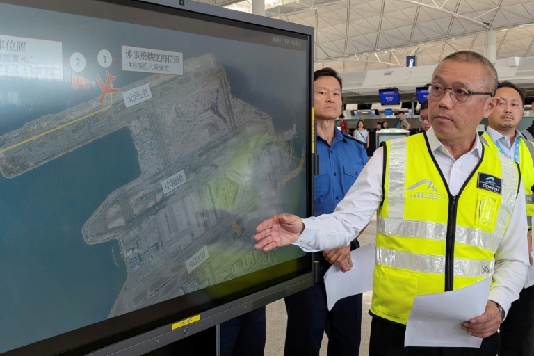 Steven Yiu, directeur exécutif des opérations aéroportuaires de l'Autorité aéroportuaire de Hong Kong, montre sur un écran l'endroit où un avion cargo Boeing a dérapé dans la mer après avoir heurté un véhicule au sol lors de son atterrissage sur la piste nord de l'aéroport de Hong Kong, le 20 octobre 2025