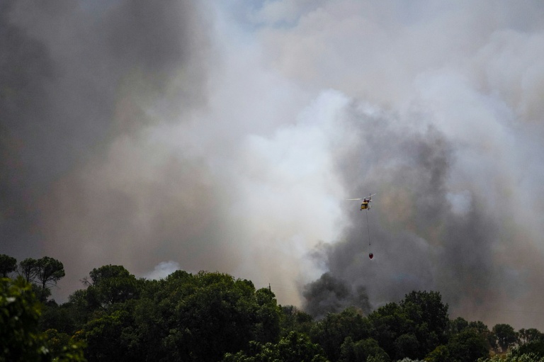 Un hélicoptère survole le 3 juillet 2026 un feu de forêt faisant rage près de La Bisbal de l'Empordà, dans le nord-est de l'Espagne, depuis contrôlé