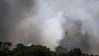 Un hélicoptère survole le 3 juillet 2026 un feu de forêt faisant rage près de La Bisbal de l'Empordà, dans le nord-est de l'Espagne, depuis contrôlé
