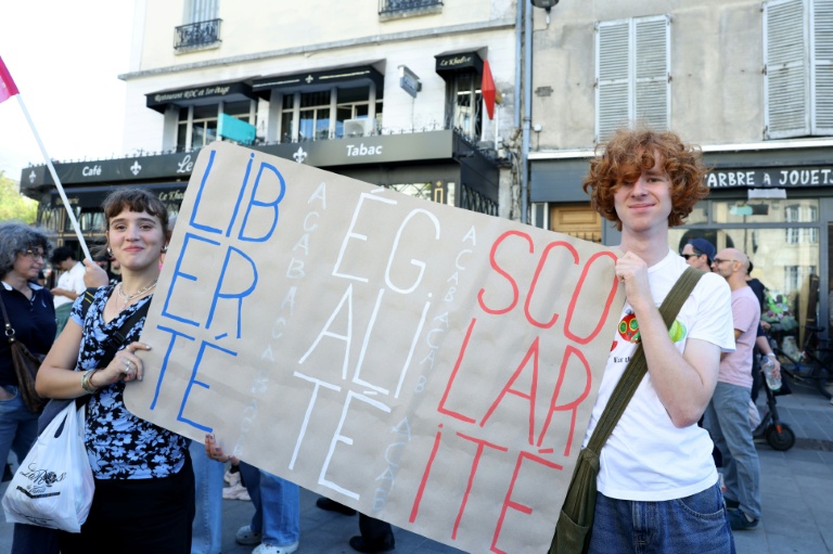 Des lycéens tiennent une pancarte portant l'inscription 