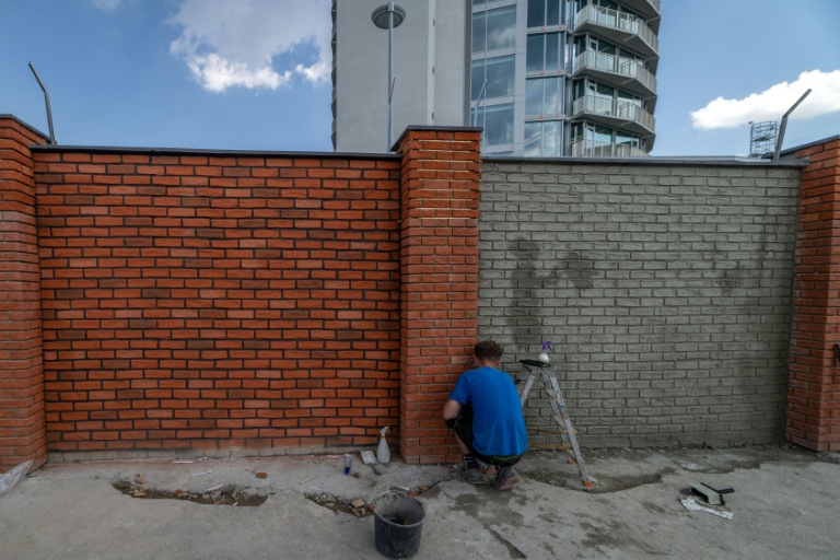 Des ouvriers repeignent le mur d'enceinte du ministère de la Défense slovaque, le 16 juillet 2026 à Bratislava