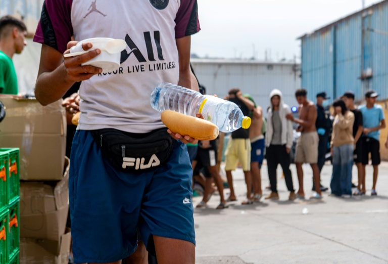 Des bénévoles de l'ONG Luna Blanca distribuent de la nourriture à des migrants sur le site industriel d'El Tajaral à Ceutae, Espagne, le 2 septembre 2026