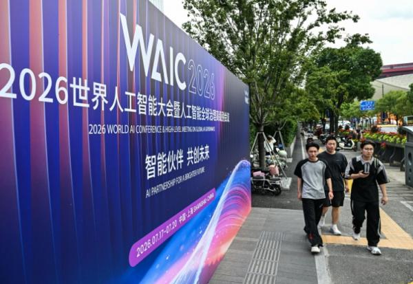 Des passants longent une affiche de la Conférence mondiale sur l'intelligence artificielle (WAIC), le 16 juillet 2026 à Shanghai en Chine