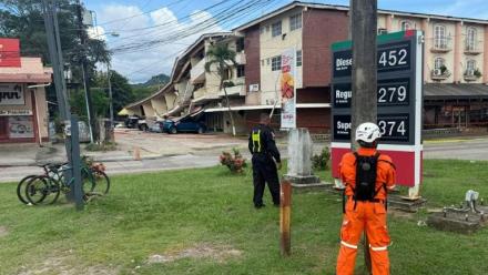 Un policier panaméen et un secouriste montent la garde à côté d'un immeuble effondré après un séisme, à Penonomé, au Panama, le 9 octobre 2026