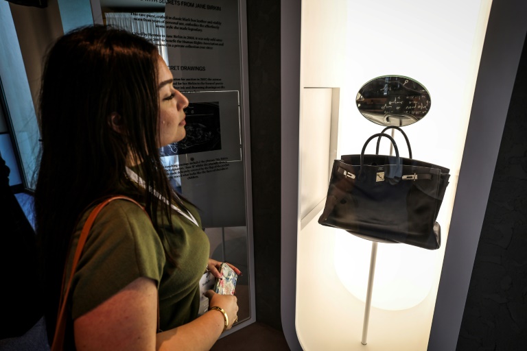 Une femme observe le sac Hermès 