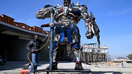 Le sculpteur Ehtisham Jadoon à côté de son Optimus Prime, personnage du film Transformers, fabriqué à partir de ferraille devant son atelier situé à la périphérie d'Islamabad, le 12 février 2026 au Pakistan