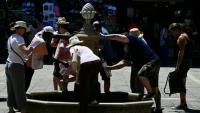 Des touristes se rafraîchissent à une fontaine publique à Venise, lors d'un épisode de canicule en Europe, le 27 juin 2026