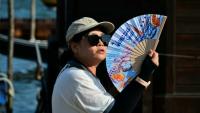 Une touriste utilise un éventail pour se rafraîchir, place Saint-Marc, à Venise, lors d'un épisode de canicule en Europe, le 26 juin 2026
