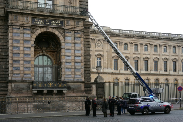 Des policiers français se tiennent à côté du monte-charge utilisé par des cambrioleurs pour pénétrer dans le musée du Louvre, sur le quai François Mitterrand, à Paris, le 19 octobre 2025