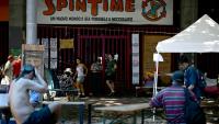 Des personnes récemment expulsées d'un centre social à Rome sont installées devant ses grilles fermées, le 11 août 2026