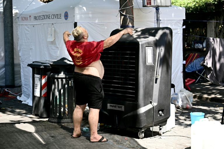 Marco Perilli, un ancien résident d'un centre social à Rome vidé récemment de ses occupants, se rafraîchit devant un ventilateur, le 11 août 2026 à Rome