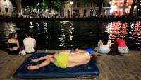 Un jeune se rafraïchit le long du canal Saint-Martin en pleine canicule à Paris le 25 juin 2026